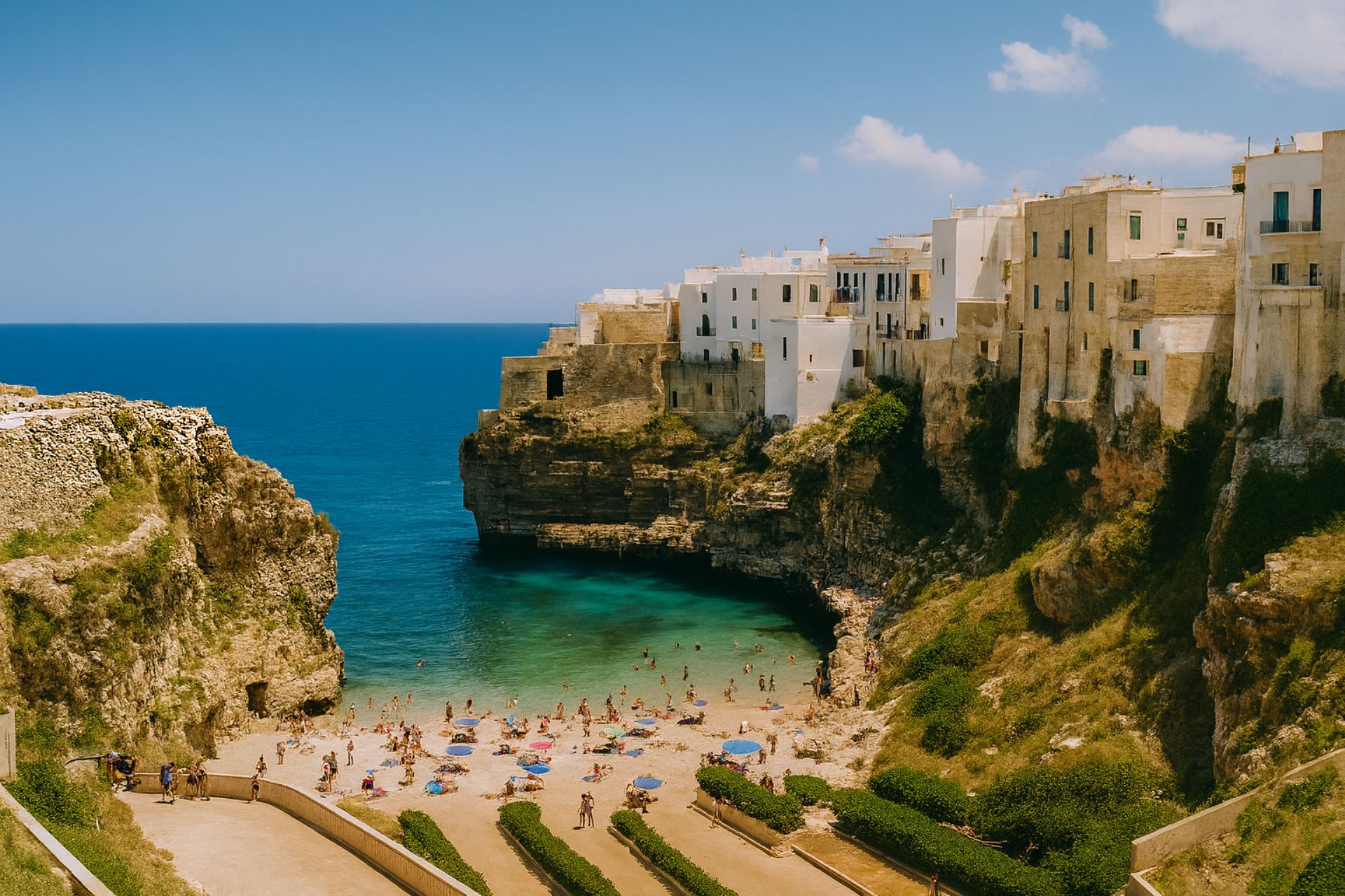 Veduta costiera di una spiaggia pugliese incastonata tra alte scogliere calcaree, con bagnanti e case bianche a picco sul mare Adriatico in una giornata estiva limpida.