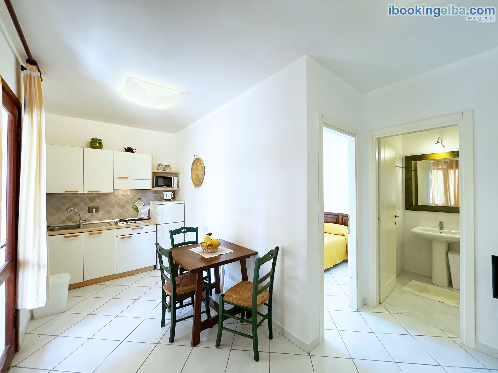 Bilocale (5) - Vista della Cucina con Angolo Cottura e Camera Matrimoniale