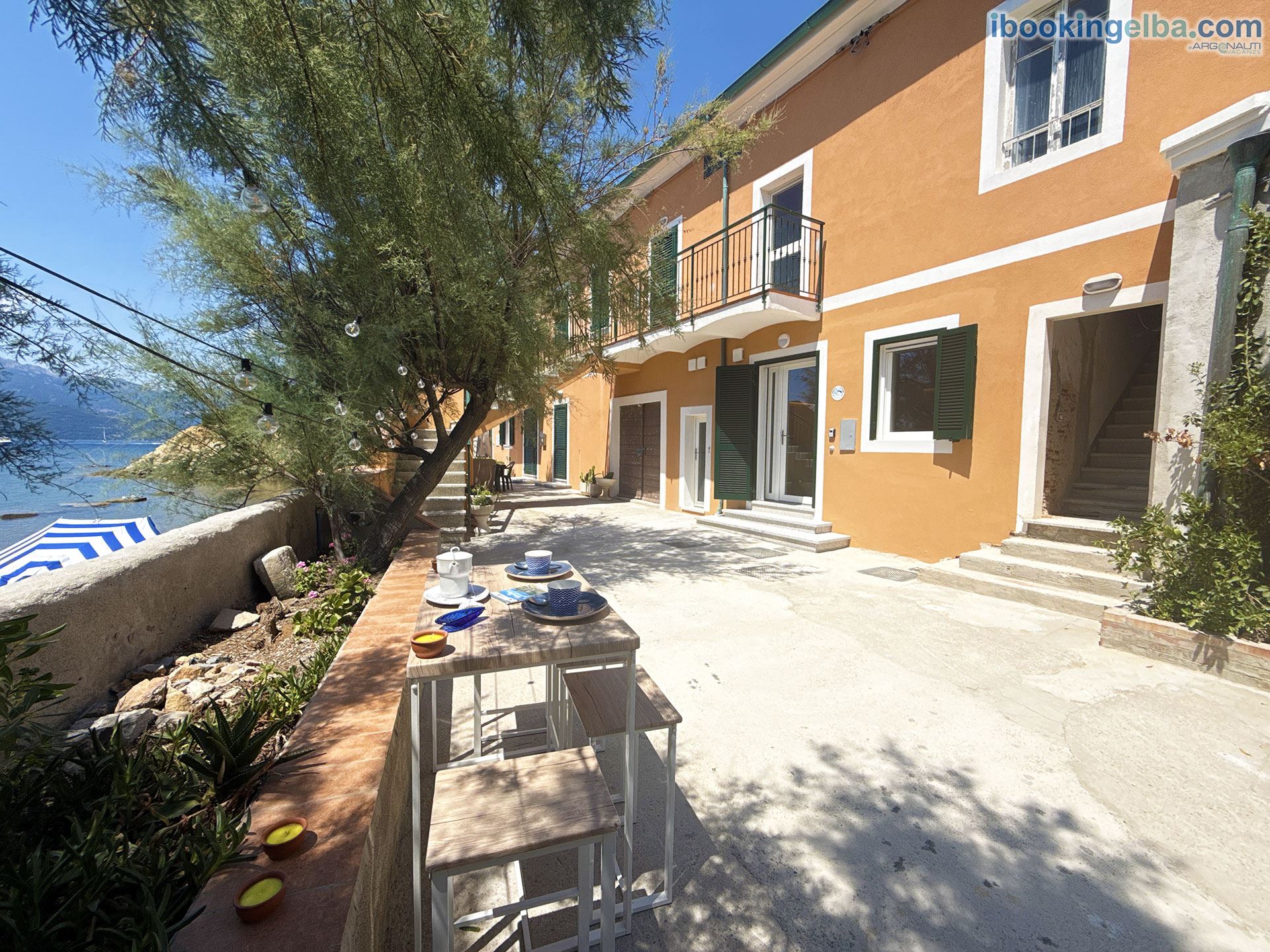 Casa Capo Enfola - Cortile vista mare con tavolinetto e sedie
